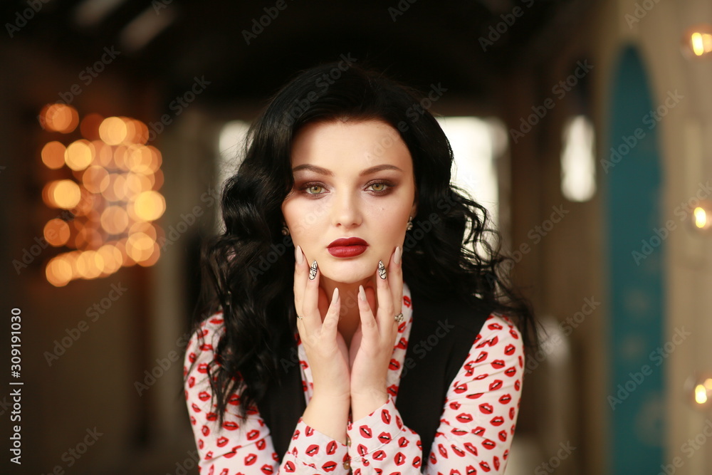 Portrait of a beautiful woman on the street with a background of blurred lights bulbs.