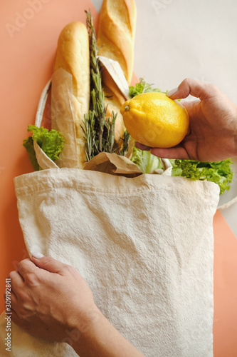 Organic vegetables long loaf in eco bag tote in market. Woman laying products in fabric linen bag in organic food store.  Healthy nutrition, Zero Waste, Concept. Banner for for web, design. Mock up photo