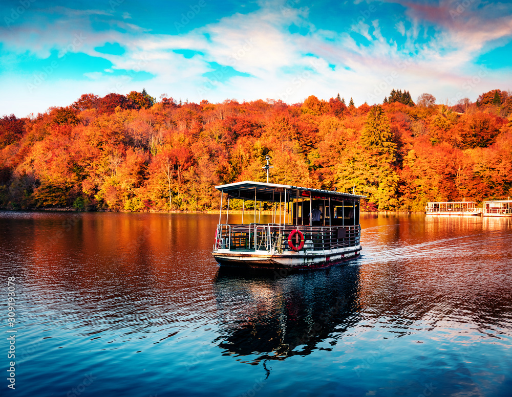 Excursion ship on the lake. Fantastic autumn sunset on Plitvice lake. Captivating morning landscape of Croatia, Europe. Traveling concept background. Excursion ship on the lake. Fantastic autumn sunset on Plitvice lake. Captivating morning landscape of Croatia, Europe. Traveling concept background.