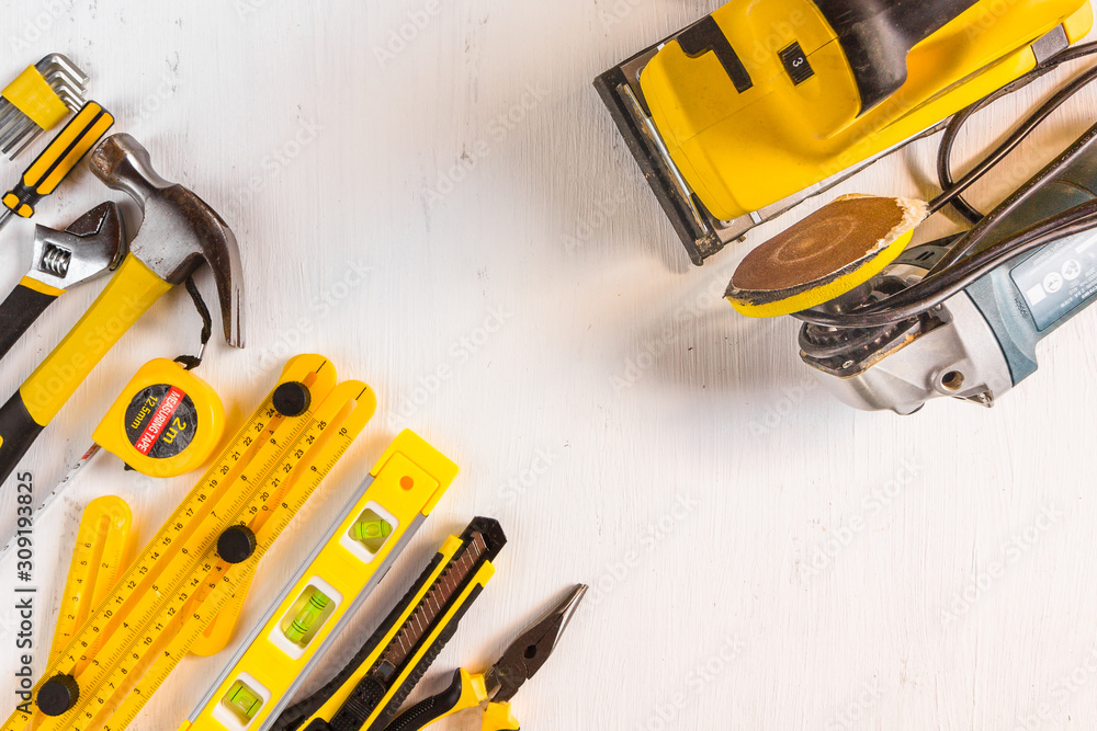 Set of yellow woodworking tools with sanding power tools on white background. Top view. Set of yellow woodworking tools with sanding power tools on white background. Top view.