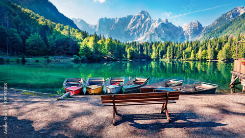 Fototapeta Naklejka Na Ścianę i Meble -  Six pleasure boats on Fusine lake. Spectacular morning scene of Julian Alps with Mangart peak on background, Province of Udine, Italy, Europe. Traveling concept background.