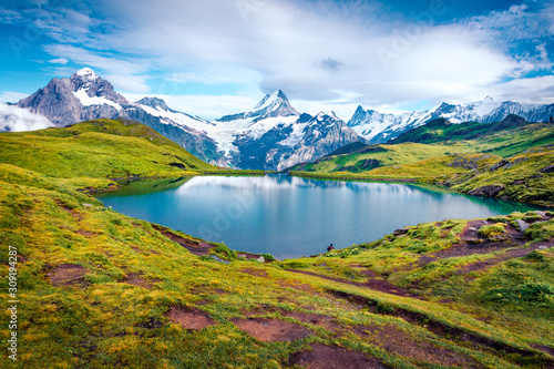 Picturesque summer view of Bachalpsee lake with Schreckhorn peak on background. Majestic morning scene of Swiss Bernese Alps  Switzerland  Europe. Beauty of nature concept background.