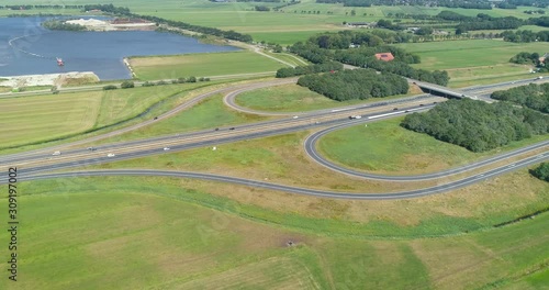 Slow Moving Shot of the A7 Highway on a Sunny Day, Exit 28, Near Drachten and Beetsterzwaag, Traffic consists of Cars and Trailers, Friesland, Netherlands / Holland – 4K Drone Footage photo