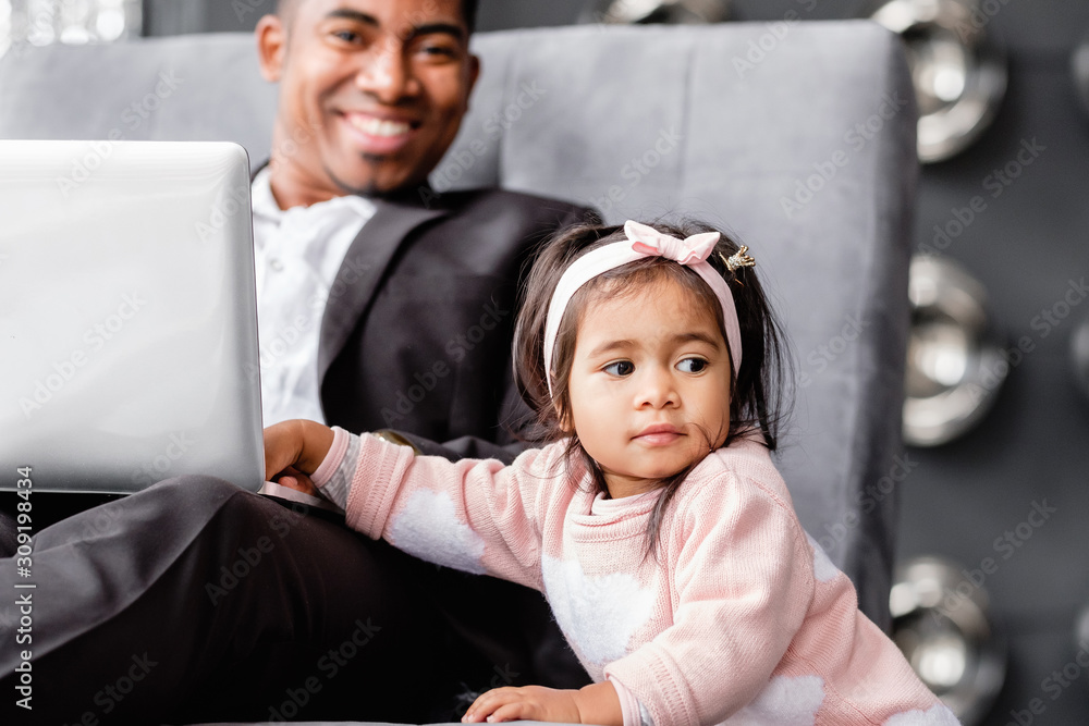 Little cute daughter distracts father from serious work. Parenting and business. African girl asks for attention of her dad. Children's attention deficit hyperactivity disorder. Family Relationships Little cute daughter distracts father from serious work. Parenting and business. African girl asks for attention of her dad. Children's attention deficit hyperactivity disorder. Family Relationships