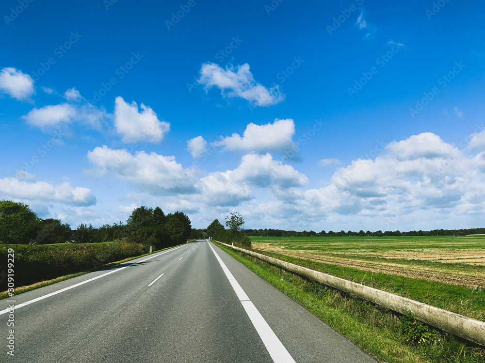 Fototapeta premium Empty asphalt road, blue sky with clouds