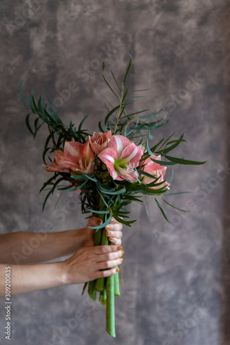 Woman's hands holding a bouquet of flowers, amaryllis