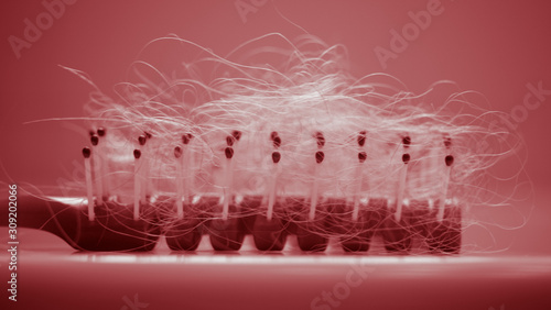 Tangled hair in comb on the table, side view, red tone.