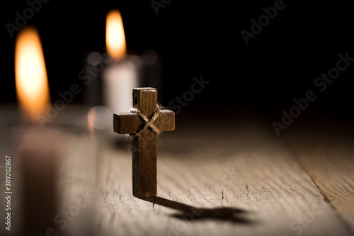 Photography Wooden cross and candles on dark background