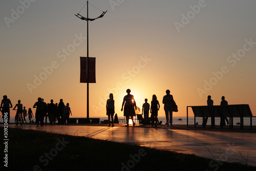 Silhouette people group on sea beach sunset background