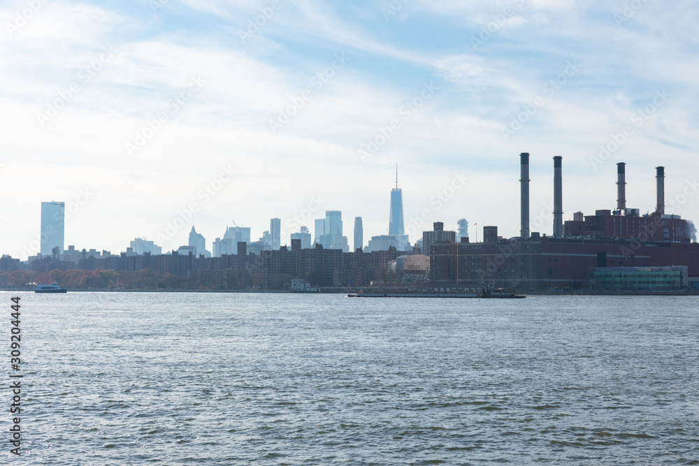 Lower Manhattan Skyline on the East River in New York City with Smoke Stacks from a Power Plant