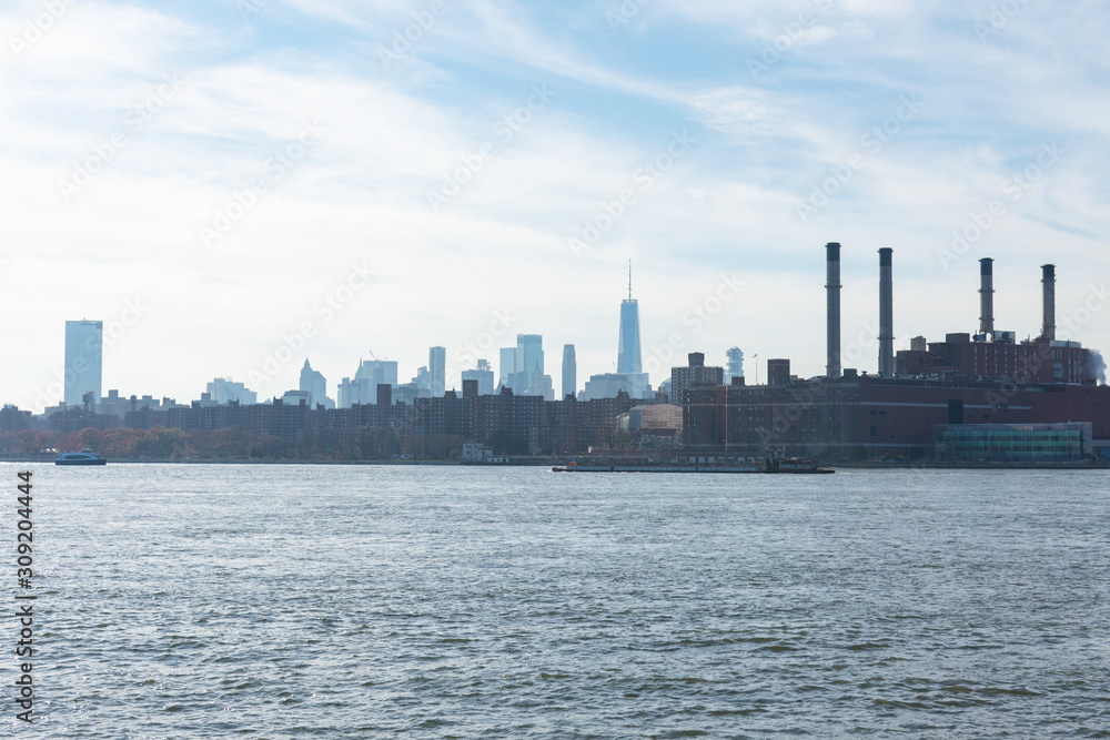 Lower Manhattan Skyline on the East River in New York City with Smoke Stacks from a Power Plant Lower Manhattan Skyline on the East River in New York City with Smoke Stacks from a Power Plant