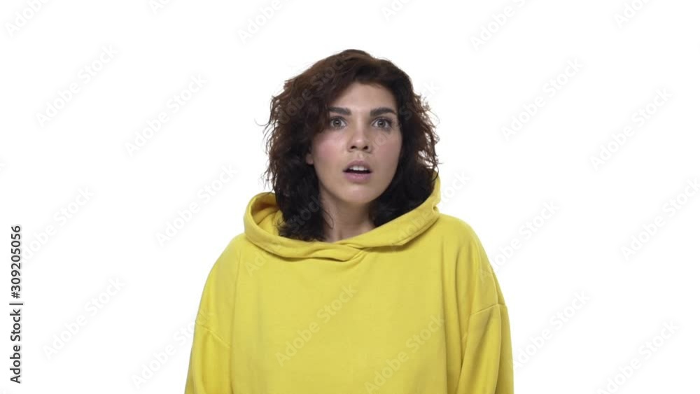 Shocked young curly-haired caucasian woman realise something shocking and speechless, gasping amazed have no words, turning sideways, touch lips and cover mouth, cant understand what happened Shocked young curly-haired caucasian woman realise something shocking and speechless, gasping amazed have no words, turning sideways, touch lips and cover mouth, cant understand what happened