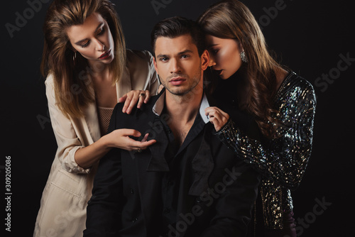 attractive and stylish women hugging handsome man isolated on black
