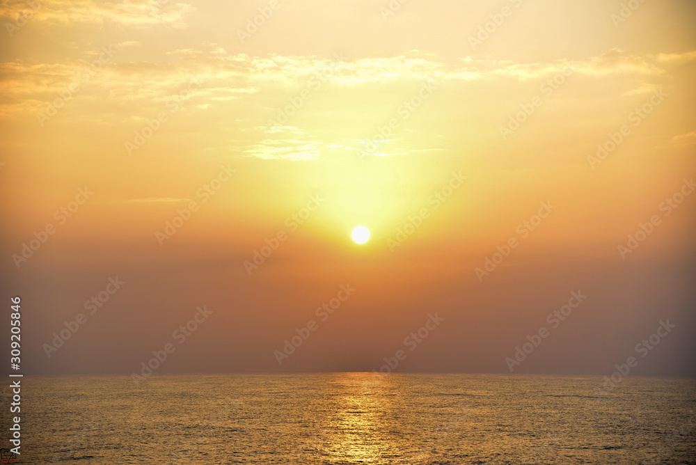 amazing photo of sunset with yellowish sky reflected over the sea 