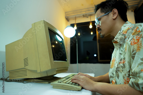 A man using an old personal computer . Ancient concept