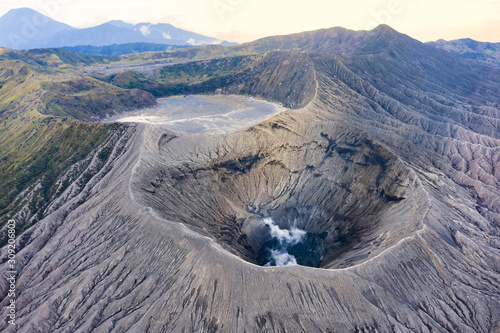 Photography View from above, stunning aerial view of the Mount Bromo with clouds of gases raising from the crater