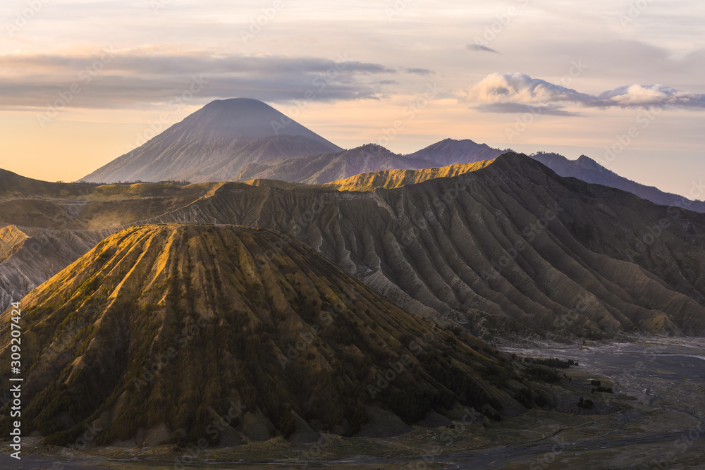 View from above, stunning aerial view of the Mount Batok, Mount Bromo and the Mount Semeru in the distance illuminated at sunrise, East Java, Indonesia.