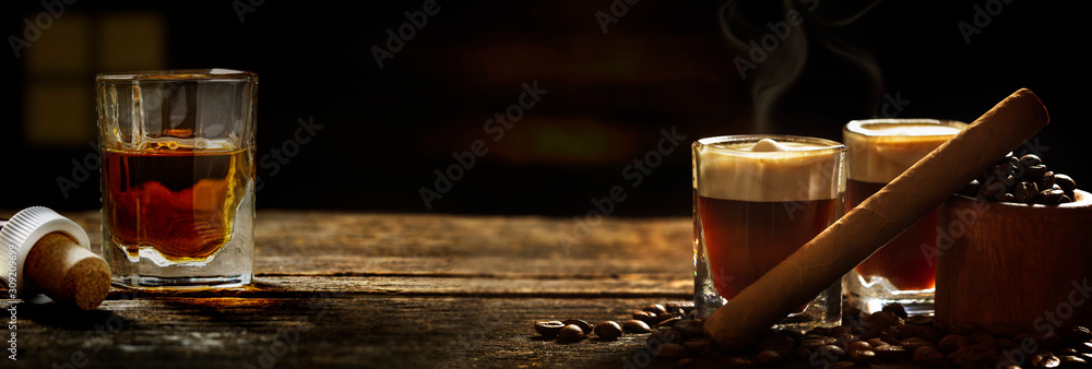 Irish coffee - coffee and whiskey and cigars against dark background