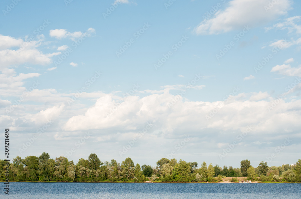Beautiful landscape. Wide blue river, trees and beautiful sky. Summer rest