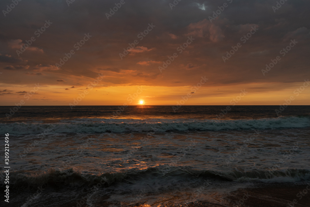Panoramic view of sunset in ocean. Nothing but sky, clouds, beach and water. Beautiful serene scene