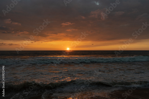 Panoramic view of sunset in ocean. Nothing but sky  clouds  beach and water. Beautiful serene scene