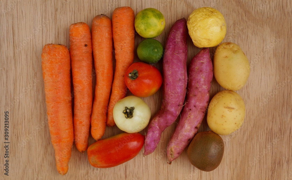 Carrots, potatoes, sweet potatoes, limes, tomatoes and kiwi fruit. Healthy life concept. Carrots, potatoes, sweet potatoes, limes, tomatoes and kiwi fruit. Healthy life concept.
