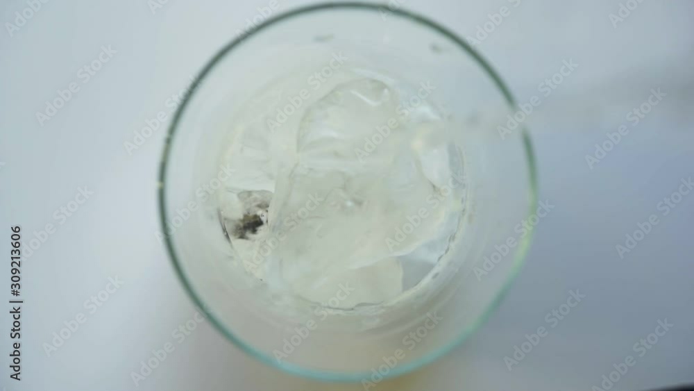 Close up slow motion pouring tasty sweet soda into glass in white background Close up slow motion pouring tasty sweet soda into glass in white background