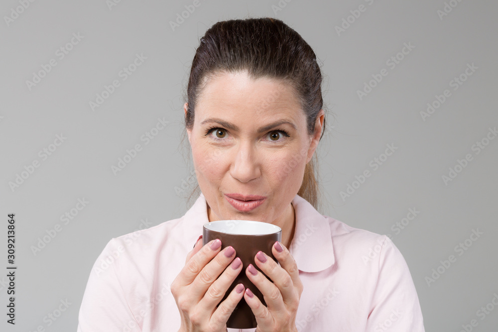 smiling middle-aged with a cup of fresh coffee or tea in her hand smiling middle-aged with a cup of fresh coffee or tea in her hand