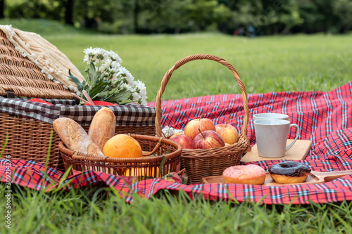 Summer time.Closeup of picnic basket with food and fruit  in nature.