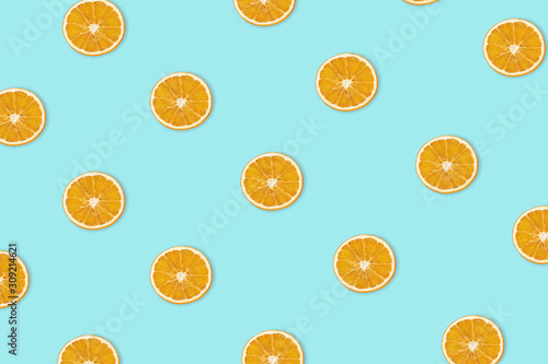 Orange pattern. Slices of dried oranges laid out on aqua menthe background. View from above.