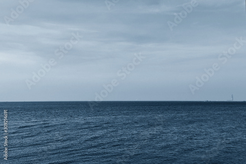 Gulf of Finland coast in classic blue. Island and sailboats on the horizon in classic blue.