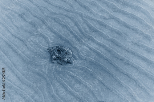 Background of the seabed sand with stone in classic blue.