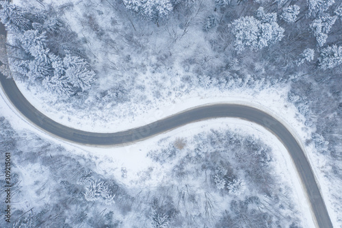 Aerial view of winter road and forest with snow covered trees, top view © Ivanna Pavliuk