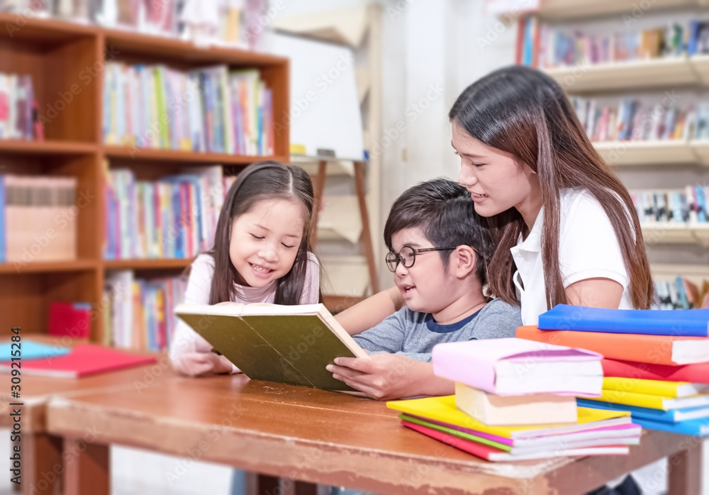 The beautiful woman and two kids reading book together,with eyjoy and happy feeling,at classroom,blurry light around The beautiful woman and two kids reading book together,with eyjoy and happy feeling,at classroom,blurry light around