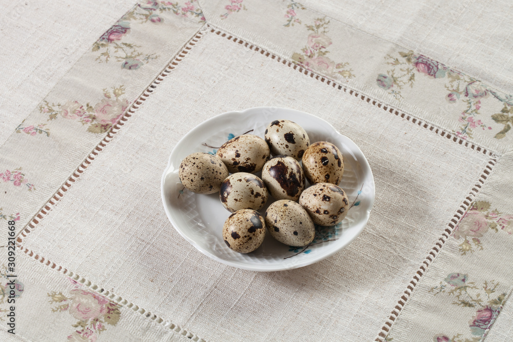 Oeufs de caille dans une soucoupe posé sur une nappe en tissu Oeufs de caille dans une soucoupe posé sur une nappe en tissu