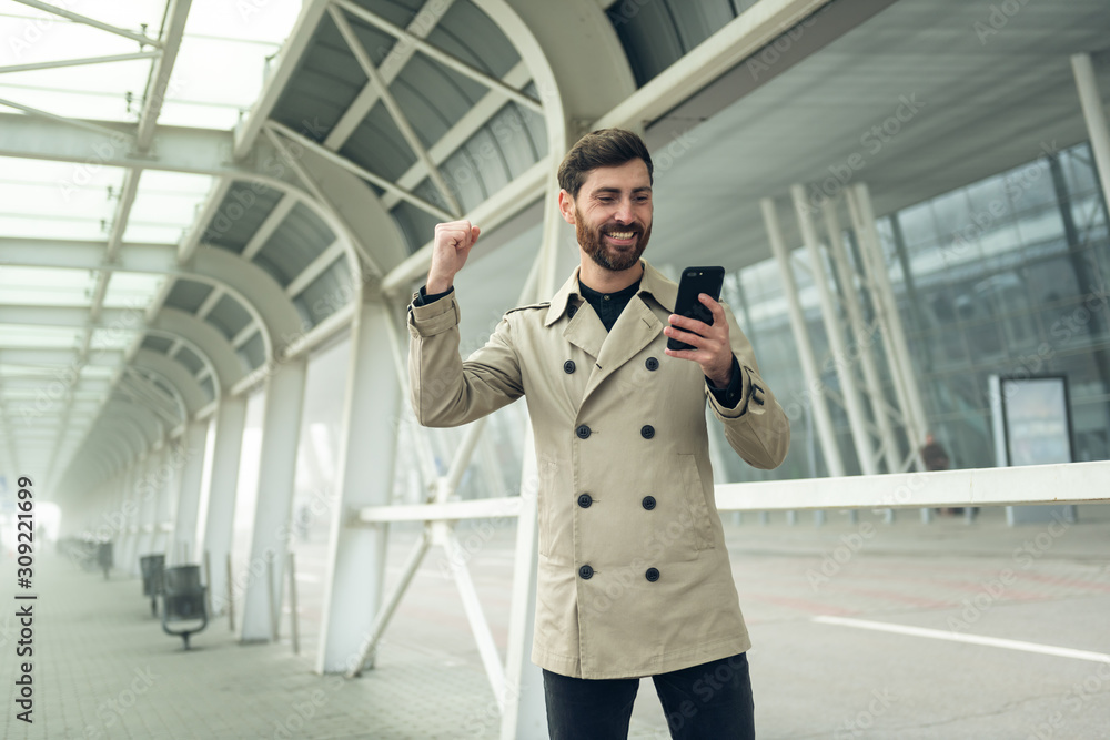 Fototapeta premium Good Business News. Businessman using smart phone.