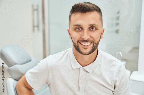 Cropped view of bearded cheerful man visiting dental office