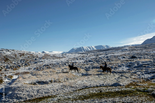 Cavalier en selle sur des chevaux islandais dans la neige en Islande