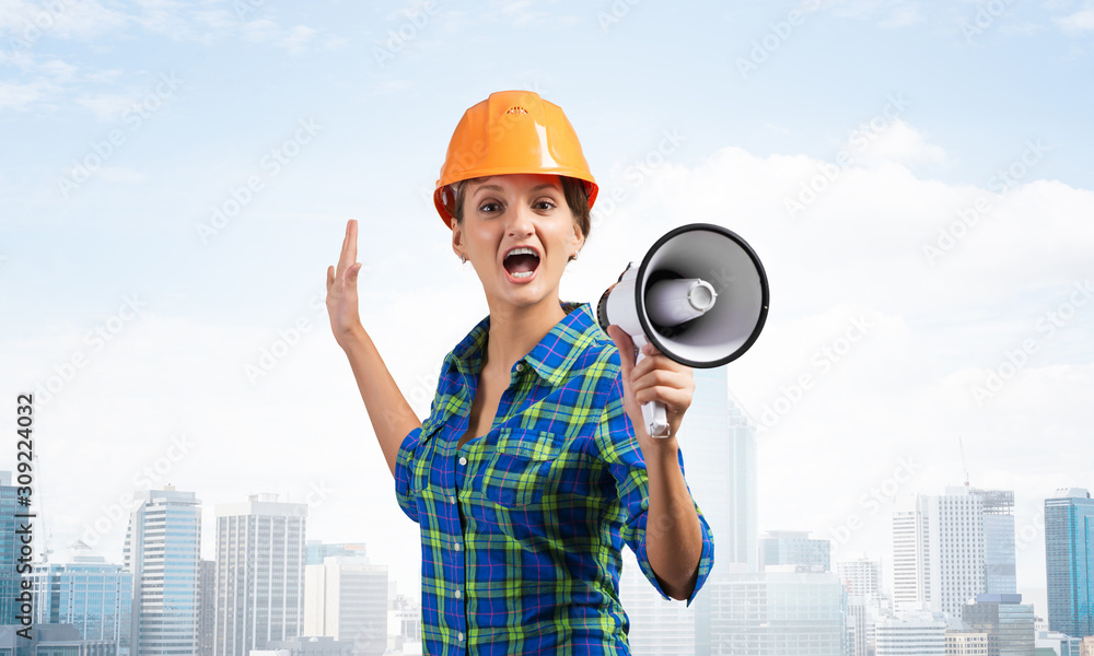 Expressive woman in helmet shouting into megaphone Expressive woman in helmet shouting into megaphone