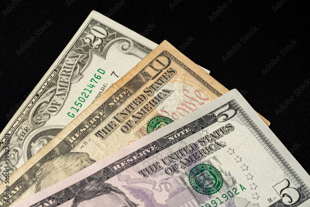 Composition of all US dollar notes stacked on a black background with space for copying. Composition of all US dollar notes stacked on a black background with space for copying.