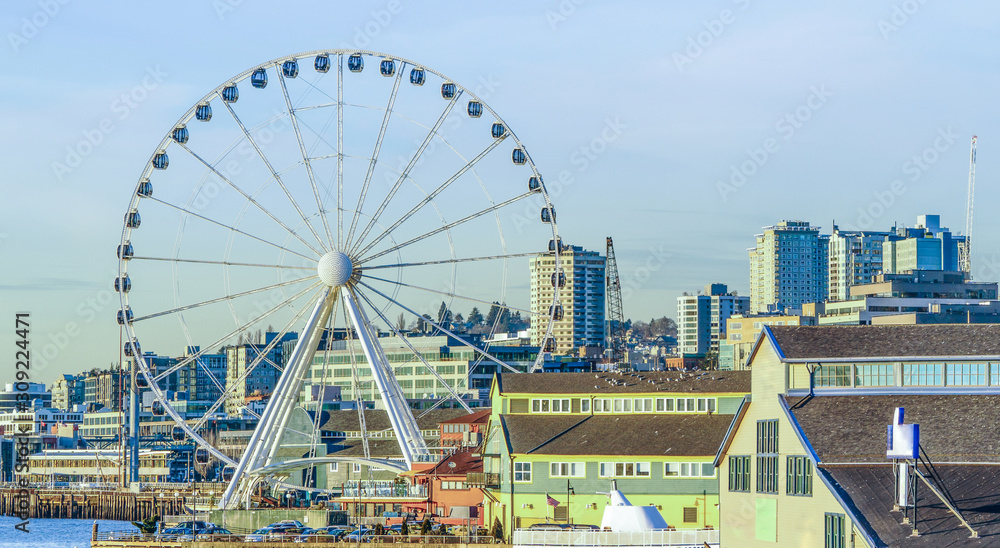 View of Seattle waterfront skyline and the Great ferris wheel in the foreground with late afternoon warm winter light.