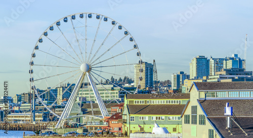 View of Seattle waterfront skyline and the Great ferris wheel in the foreground with late afternoon warm winter light.