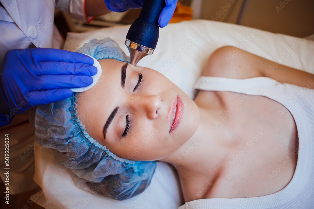 Cosmetology doctor makes woman treatments facial massage Cosmetology doctor makes woman treatments facial massage