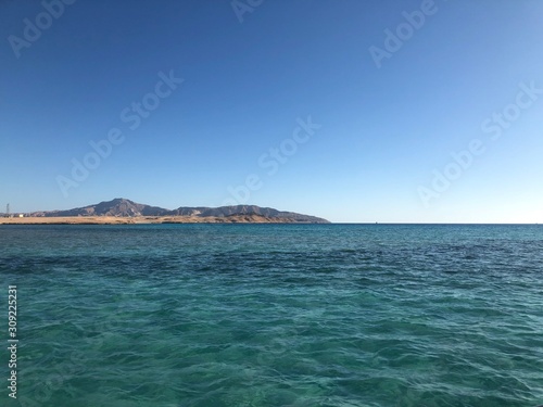 Landscape of tropical ocean with Tiran island on turquoise ocean waves, blue sky. Picture of vacation and travel to Egypt. © korolkoff