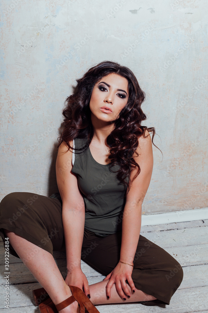 Fototapeta premium girl in green dress sits on the wooden floor