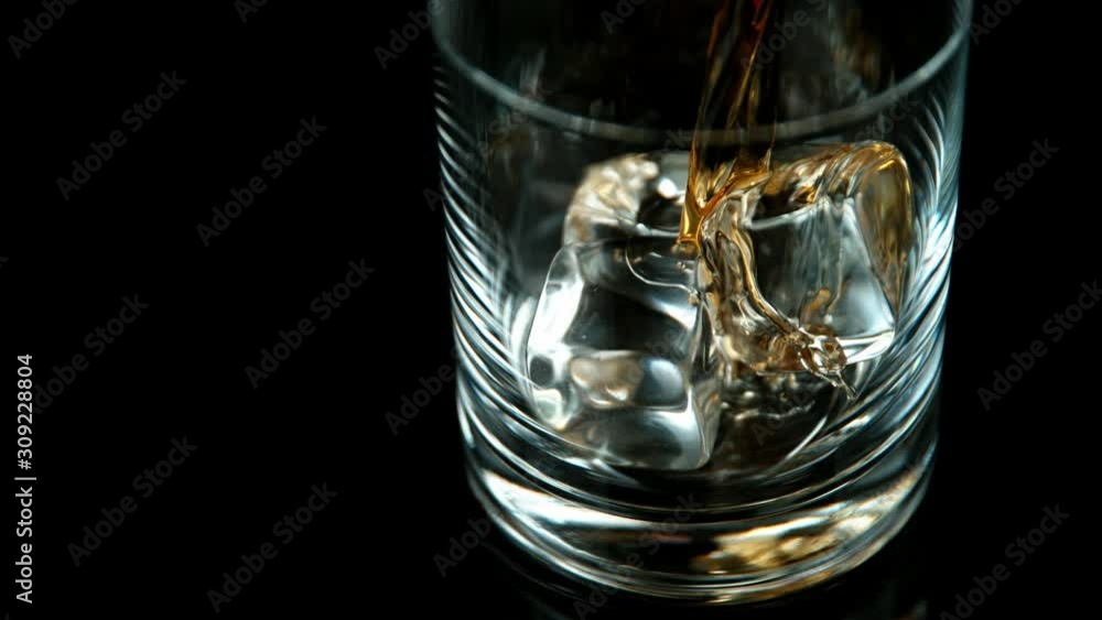 Super slow motion of pouring whiskey or rum with slide motion. Filmed on high speed cinema camera, 1000 fps Super slow motion of pouring whiskey or rum with slide motion. Filmed on high speed cinema camera, 1000 fps
