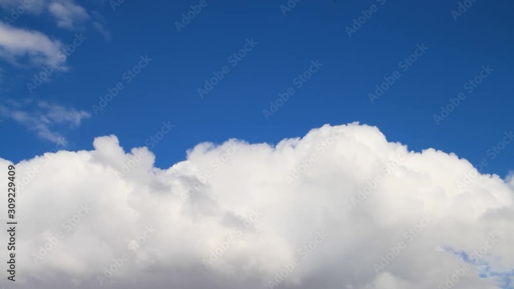Fluffy white clouds roll across the bottom of this one minute long seamles time lapse weather video loop with a deep blue sky above Fluffy white clouds roll across the bottom of this one minute long seamles time lapse weather video loop with a deep blue sky above