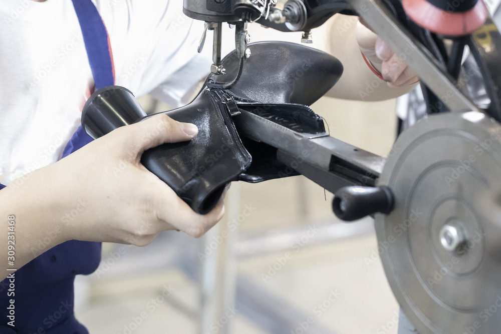 Cropped image of young shoemaker in workshop making shoes. Cropped image of young shoemaker in workshop making shoes.