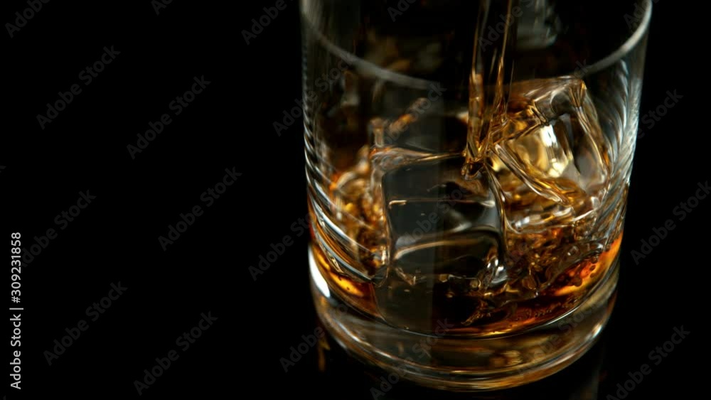 Super slow motion of pouring whiskey into glass. Filmed on high speed cinema camera, 1000fps Super slow motion of pouring whiskey into glass. Filmed on high speed cinema camera, 1000fps