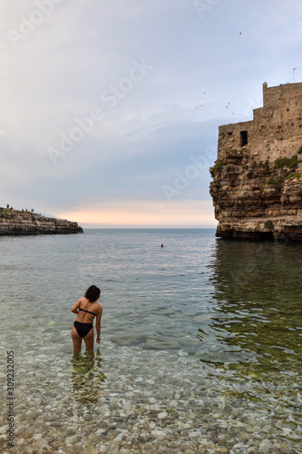 donna fa il bagno in mare vicino alle rocce